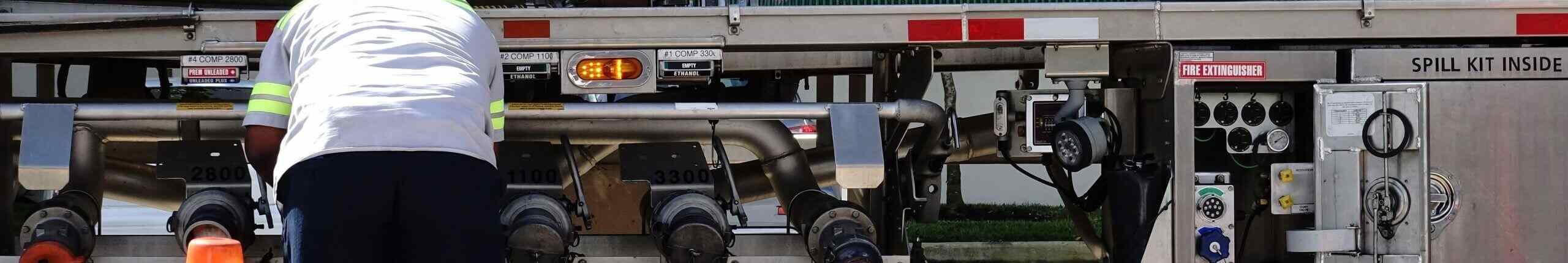 Fuel delivery driver checks the valves as gas is delivered from