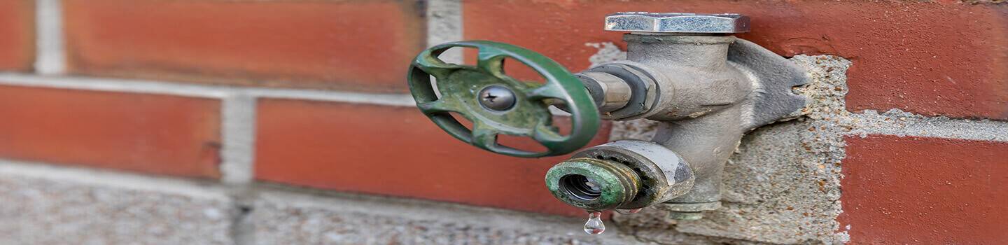 Old, corroded water spigot, faucet, or tap leaking and dripping