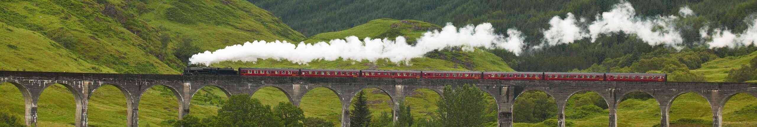 Scottish steam train passing a classic bridge