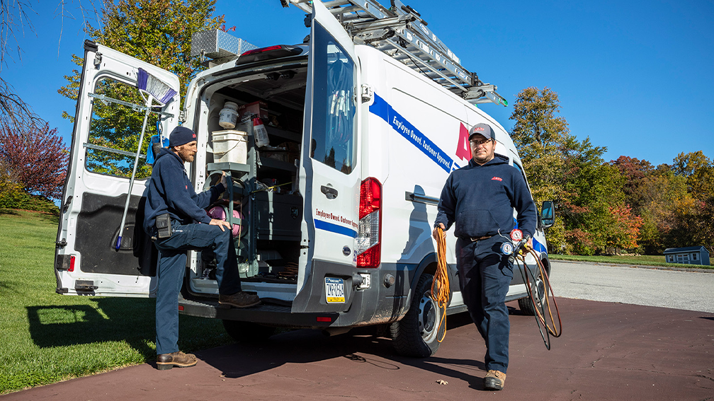 Aero Energy technicians carry supplies from their van.