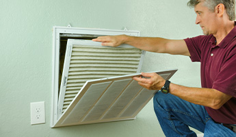 Man changes air filter at home.