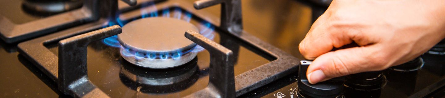 Man adjusts a gas stove.