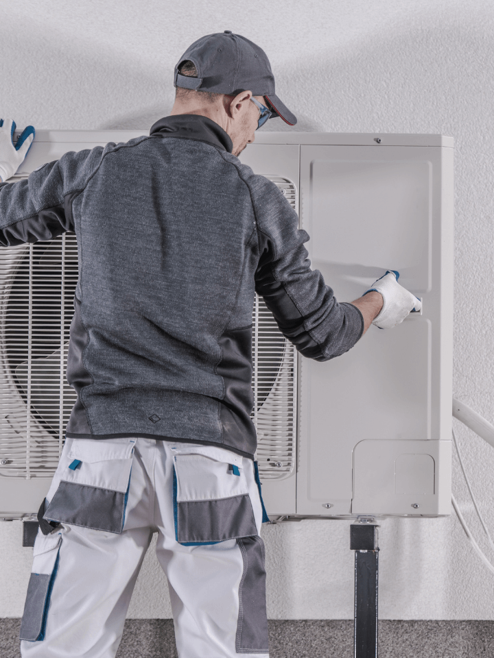 A technician works on a home's heat pump.