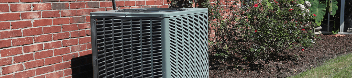 HVAC system sits adjacent to a brick wall.