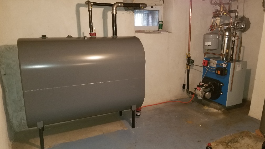 Heating oil tank rests in a basement adjacent to HVAC equipment.