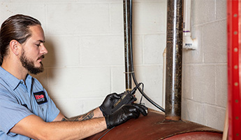 Technician inspects tank to see if it's time for replacement.