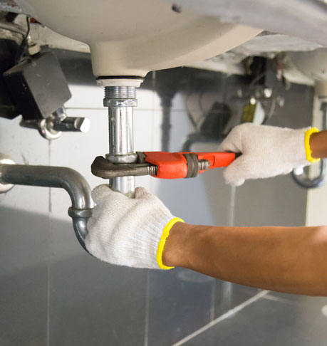 Plumber fixing white sink pipe