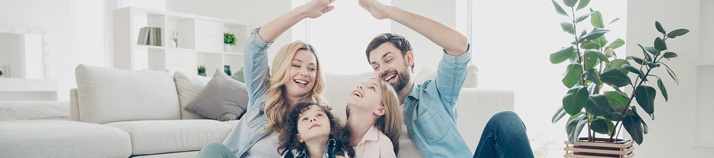 Family sits happily in living room.