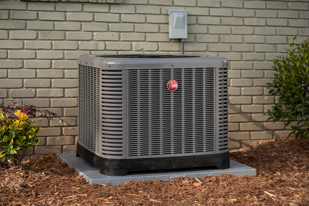 A Rheem HVAC system sits outside a home.