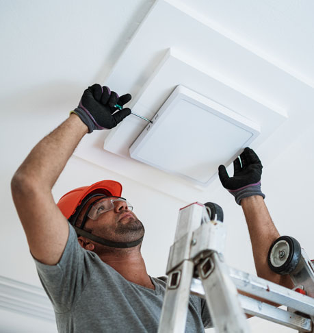 electrician installing a led light on the ceiling