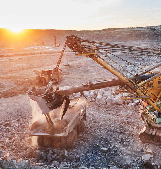 excavator loading granite into truck