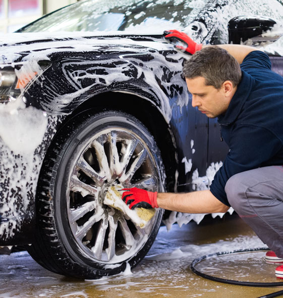 man washing car's alloy wheels